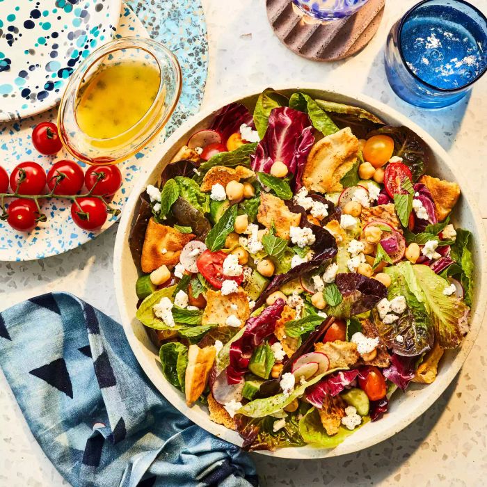 Lemony Chopped Salad offers a burst of vibrant flavors, featuring crisp roasted chickpeas, crunchy pita croutons, and an array of other fresh vegetables. The spicy radishes and refreshing cucumber slices shine through, all complemented by a tangy yet sweet lemon-honey dressing that brings it all together.
