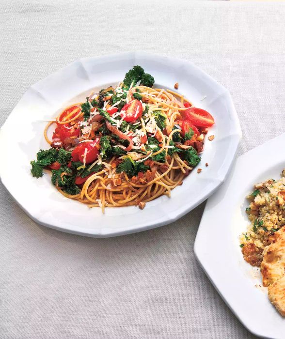 Whole Grain Spaghetti with Kale and Tomatoes Served on a White Plate