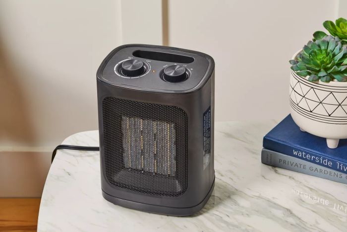 Kismile Portable Electric Space Heater placed on a table alongside books and a plant