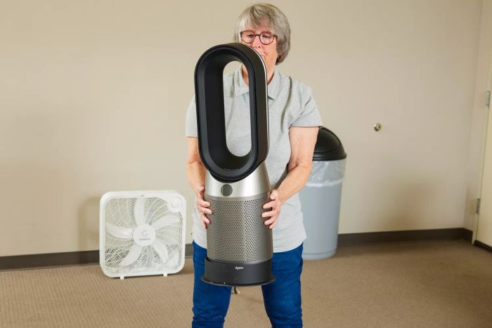 A person lifting the Dyson Purifier Hot+Cool HP07
