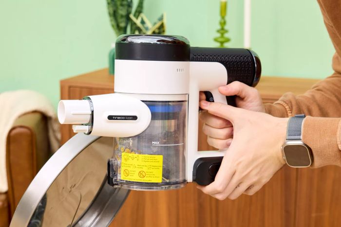 Two hands firmly grasping the handle of the Tineco Pure One S15 Pro Vacuum.