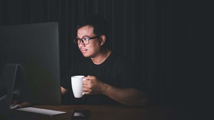 programmer holding a cup of coffee