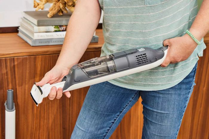 A person assembling the handheld portion of the Shark WS642AE Wandvac Cordless Stick Vacuum