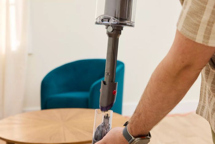 A person removing the cap from the Dyson Gen5detect Cordless HEPA Vacuum.