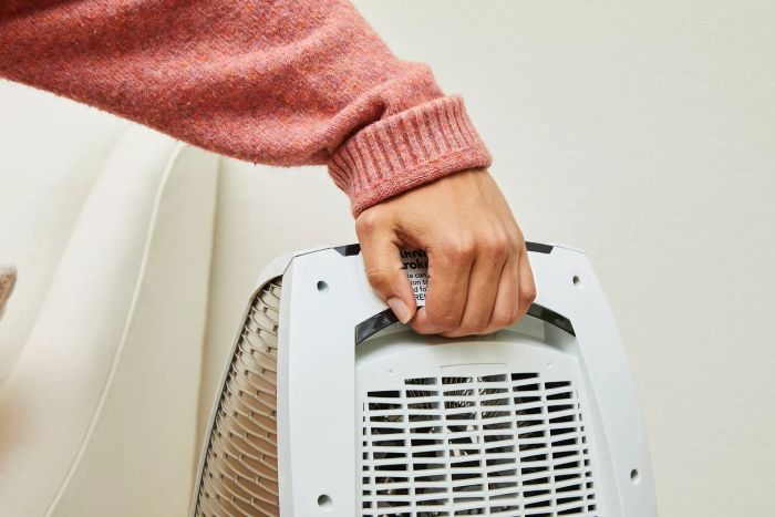 A person carrying the Vornado AVH10 Vortex Heater using its handle