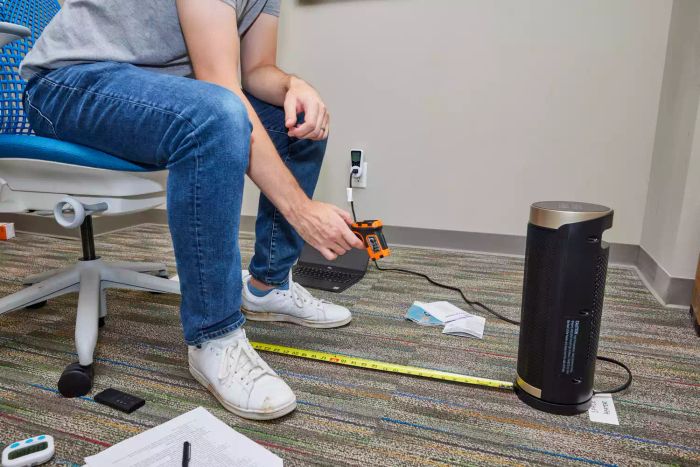A person measuring the heat output of the Dreo Solaris Slim H3 Space Heater