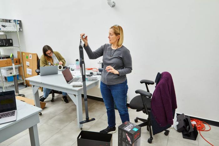 A person weighing the eufy by Anker HomeVac H30 Infinity Cordless Vacuum.