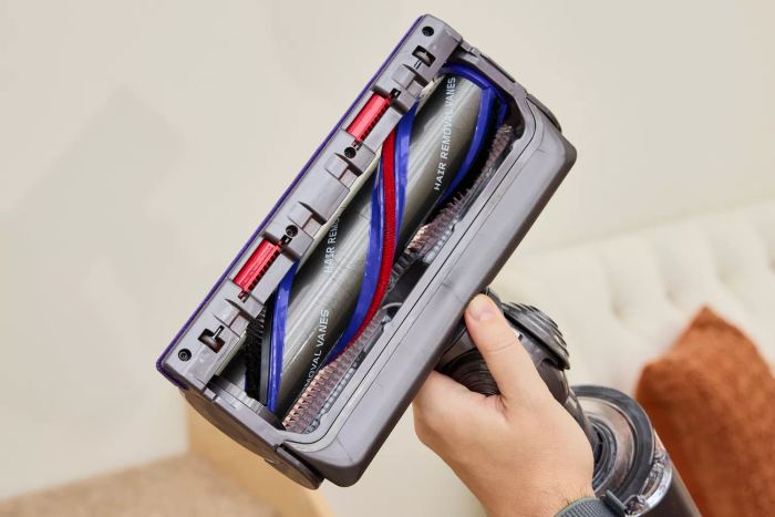 A hand holding the underside of the Dyson Gen5detect Cordless HEPA Vacuum.
