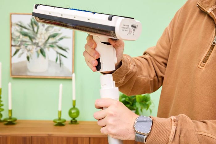 A person detaching the head of the Tineco Pure One S15 Pro Vacuum for cleaning or attachment changes.