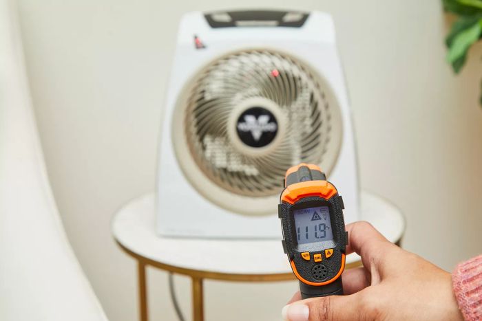 A person using a temperature gun to measure the heat output of the Vornado AVH10 Vortex Heater