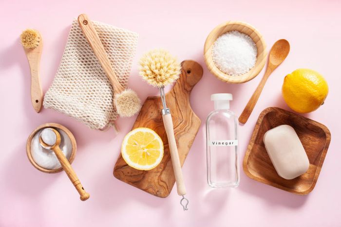 Eco-conscious cleaning tools: wooden brushes, lemon, baking soda, and vinegar