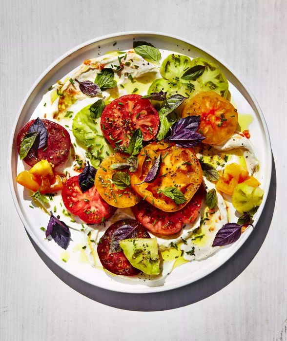 Tomatoes paired with ricotta cheese and fresh herbs create a simple yet flavorful dish.