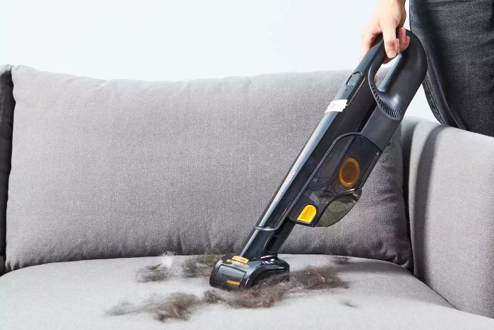 Shark UltraCyclone Pet Pro+ Cordless Handheld Vacuum cleaning pet hair from a grey couch
