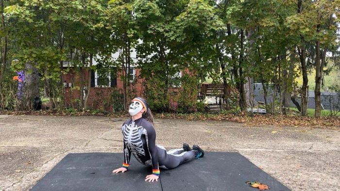 cobra pose (performed by someone dressed as a skeleton with sweatbands on)