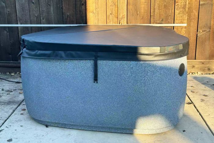 Aquarest Spas, powered by Jacuzzi® Pumps, offers the Premium AR300, a 2-person, 20-jet, oval plug-and-play hot tub with an Ozonator, set up on a patio during the daytime
