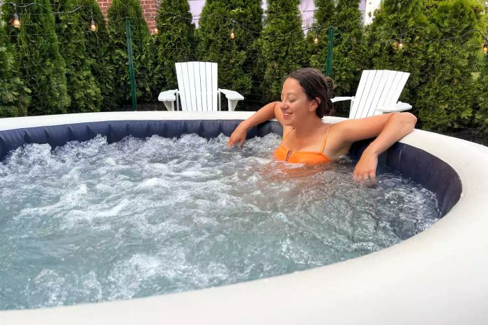 A person unwinds in the Intex PureSpa Plus 6-Person Portable Inflatable Hot Tub.