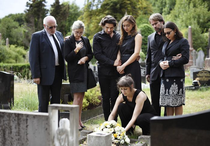A family placing flowers on a gravesite