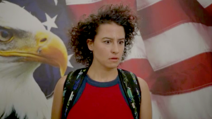 Ilana Glazer appearing stunned in front of the Stars and Stripes