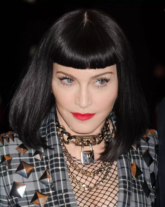 Shoulder-length haircuts featuring an angled long bob with heavy bangs bring structure and edge to the style, making it an ideal choice for straight hair.