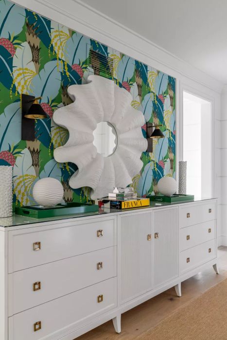 A vibrant tropical wallpaper paired with a white dresser and mirror