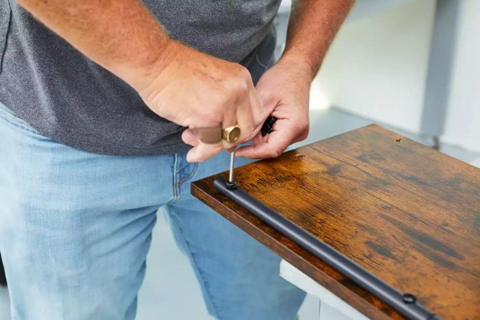 Close-up of a person putting together the Vasagle 5-Tier Shoe Rack on a table
