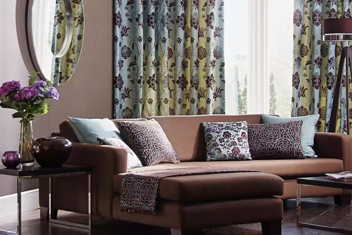 Modern living room with a stylish sofa, curtains, mirror, and decorative accents