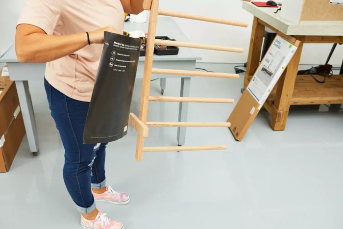 A person holding The Container Store 4-Pair Natural Boot Rack