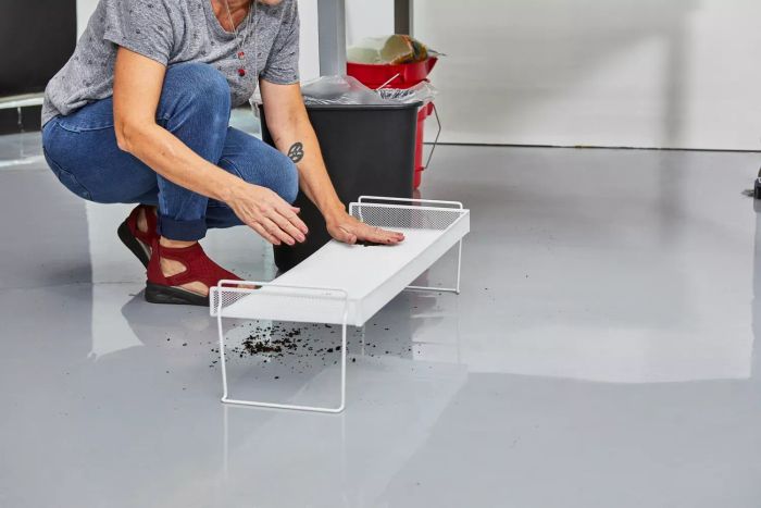 A woman applying dirt to The Container Store White Mesh Stackable Shoe Shelf