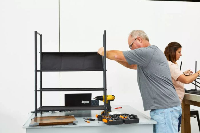 A person assembling the Vasagle 5-Tier Shoe Rack on a table with tools nearby