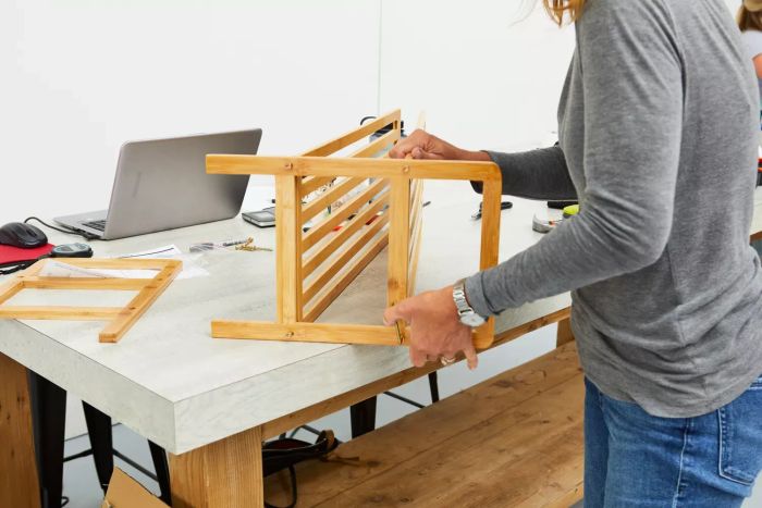 A tester assembling the Rebrilliant 2-Tier 8-Pair Shoe Rack on a table