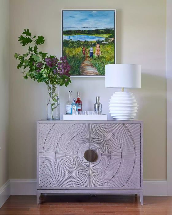 a soft purple cabinet adorned with artwork and floral accents