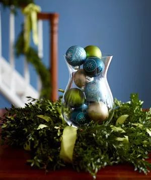 Christmas decoration ideas - Christmas ornaments in a glass vase surrounded by a wreath