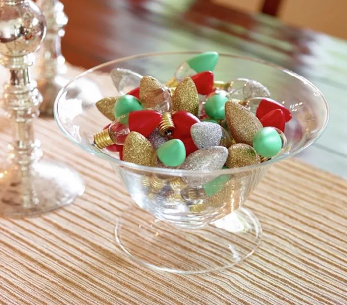 A glass bowl filled with shimmering holiday light bulbs