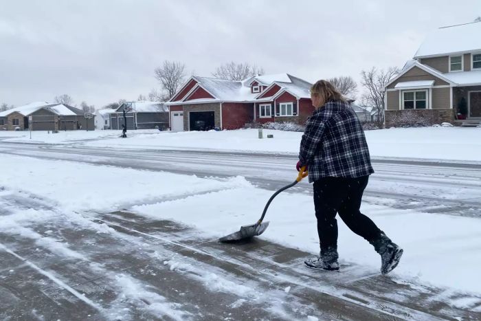 A person is clearing snow from the road using the True Temper 18-Inch Steel Snow Shovel.