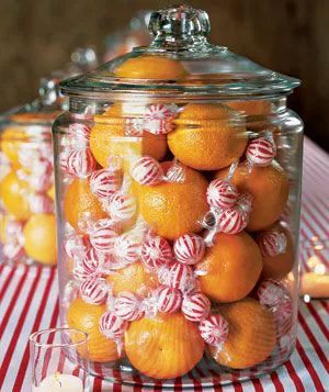 A centerpiece featuring clementines and peppermint balls elegantly arranged in a glass jar
