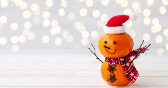 Holiday snowman crafted from tangerines, cloves, and winter berries