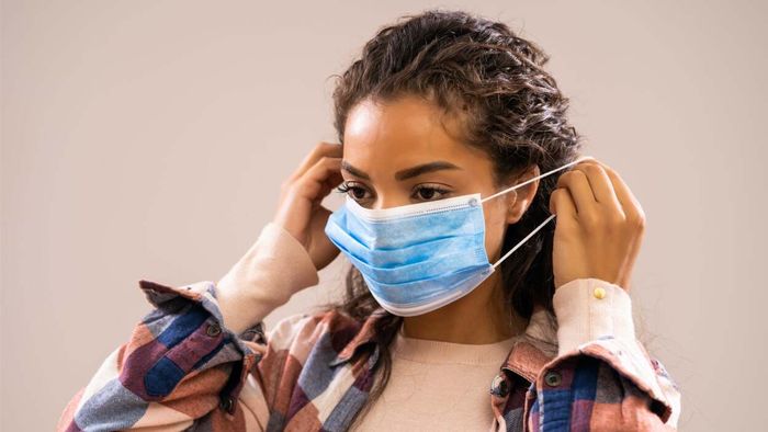 a woman adjusting her face mask