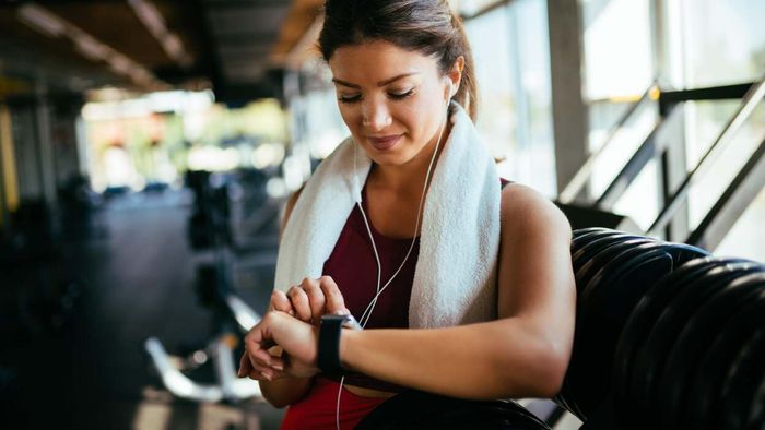 A female gym-goer checks the time on her watch
