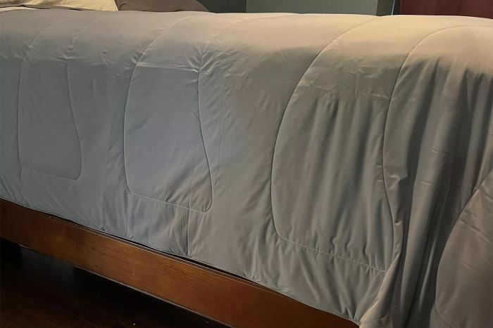 Cooling comforter laid out on a wooden bed