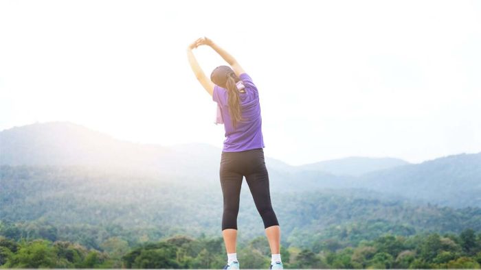 a person doing morning stretches, possibly preparing for a run