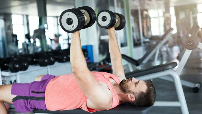 A person performing the dumbbell bench press exercise