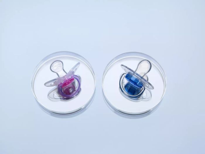 Blue and pink pacifiers in petri dishes
