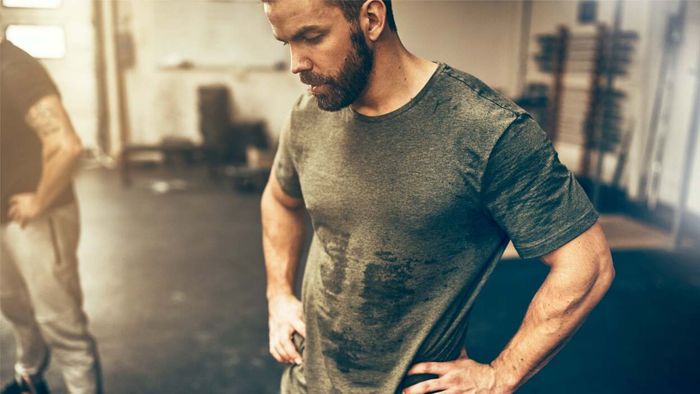 A man in a gym, deep in thought