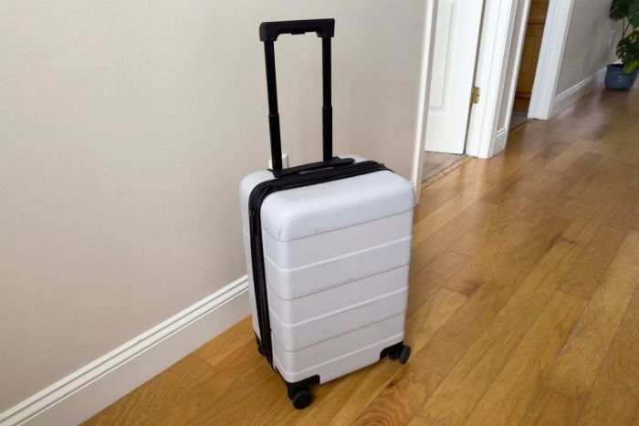 The Open Story Hardside Carry-On Spinner Suitcase with its handles raised for easy lifting.