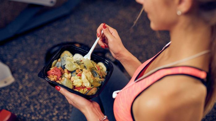 Individual consuming vegetables at the gym