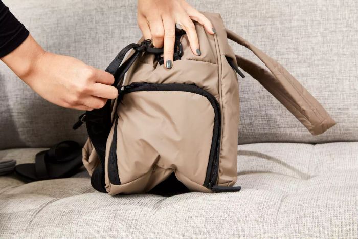 Hands adjusting the shoulder strap of the Calpak Luka Duffel Bag
