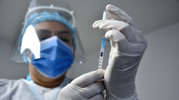 healthcare worker drawing a vaccine into a syringe