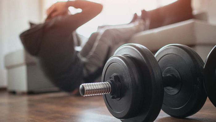 dumbbell in the front, exerciser positioned behind