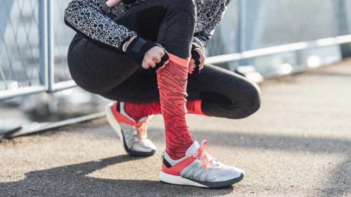 a runner adjusting her socks
