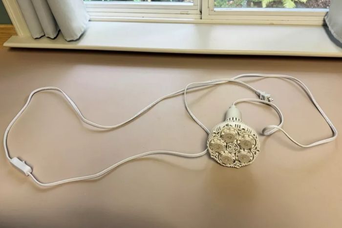 The Sansi Full Spectrum 24W Grow Light Bulb placed on a table.